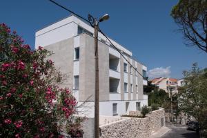 a white building with pink flowers in front of it at Paulina in Dubrovnik