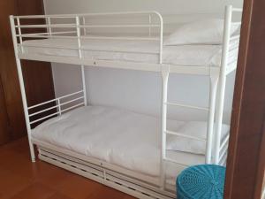 セジンブラにあるSesimbra Terrasseの白い二段ベッドが備わる客室です。