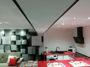 a kitchen and dining room with a red and black wall at Los Ángeles Valderrobres in Valderrobres
