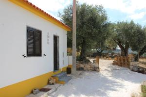a white and yellow house with trees in the background at Turismo Rural casa da céu in Amiães de Cima