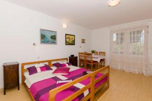 ein Schlafzimmer mit einem großen Bett mit lila und weißen Kissen in der Unterkunft Apartment Maslina in Vodice