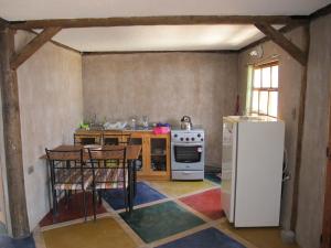 uma cozinha com um fogão, uma mesa e um frigorífico em Hospedaje Boutique Ckamur em Caldera