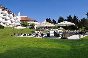 a patio with tables and chairs and umbrellas at Hotel Marbella Resort in Maitencillo