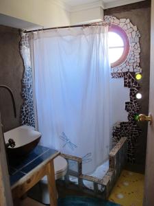 a bathroom with a shower curtain and a sink at Hospedaje Boutique Ckamur in Caldera