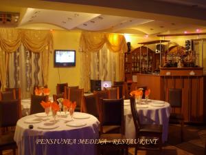 Un restaurante o sitio para comer en Pensiunea Medina