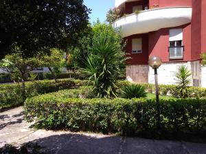 a red building with bushes in front of a building at Casa de Diego in Francavilla al Mare