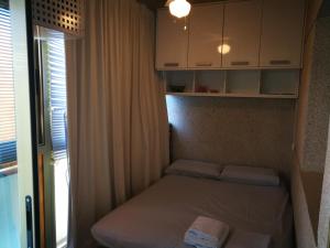 サロウにあるApartment in Salou, Escaladeiの窓付きの小さな部屋の小さなベッド1台分です。