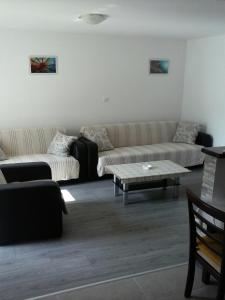 a living room with couches and a coffee table at Apartmani Marić in Selce