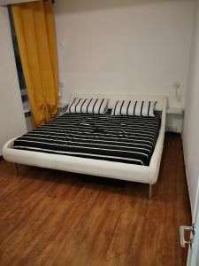 ジェノヴァにあるinside my cityのウッドフロアの客室の白いベッド1台