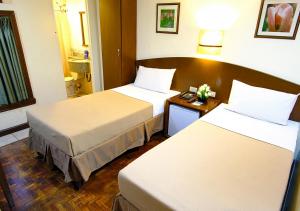 a hotel room with two beds and a table at Fersal Hotel - Manila in Manila