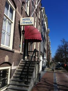 
a red brick building with a red umbrella on it's side at OZO Hotels Armada Amsterdam in Amsterdam
