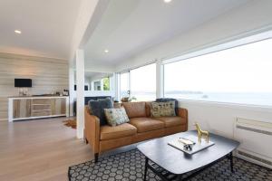 a living room with a couch and a table at Luxury house with Clifftop Seaview in Whangaparaoa