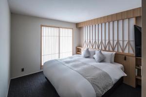 מיטה או מיטות בחדר ב-Tomoya Residence Hotel Kyoto