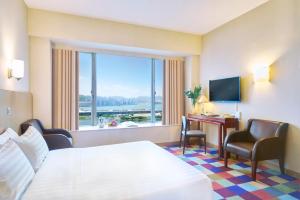 una camera d'albergo con letto, scrivania e finestra di Hotel COZi Harbour View a Hong Kong