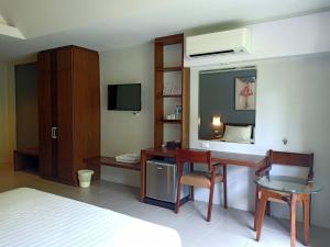 a bedroom with a desk and a bed with a television at Aonang Eco Inn Krabi in Ao Nang Beach