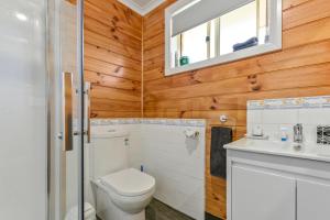 a bathroom with a toilet and a sink at Masons Cottages in Taranna