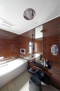 a bathroom with a bath tub and a bath tub at Urbain Kyoto Kiyomizugojo in Kyoto