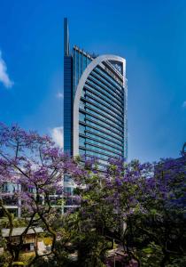 a tall building with purple trees in front of it at Felton Grand Hotel Chengdu in Chengdu