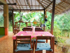 a table with chairs and a table with a pink tablecloth at Les Fleurs House in Khao Lak