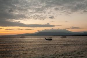 a group of boats in the water at sunset at Blue Marine Resort in Gili Air