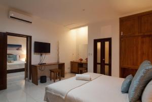 a hotel room with a bed and a television at Blue Marine Resort in Gili Air