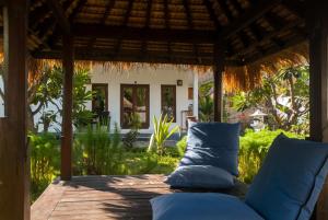 a couch under a pergola on a patio at Blue Marine Resort in Gili Air