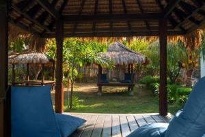 a patio with two blue chairs and a swing at Blue Marine Resort in Gili Air
