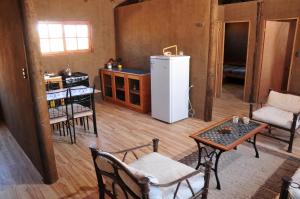 a kitchen with a refrigerator and a table and chairs at Hospedaje Boutique Ckamur in Caldera