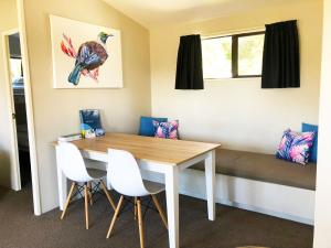 a dining room with a table and white chairs at Motutere Bay TOP 10 Holiday Park in Turangi