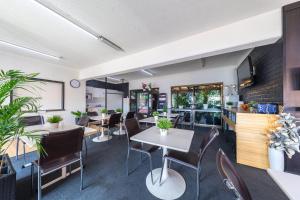 Ascot Budget Inn & Residences في بريزبين: غرفة طعام مع طاولات وكراسي في مطعم