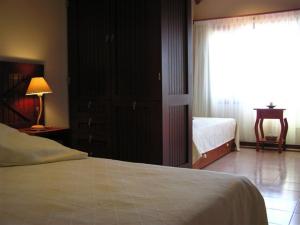 a bedroom with a bed and a window and a table at Hotel Los Pinares in San Pedro