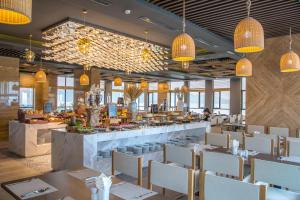 um restaurante com mesas e cadeiras e um bar em HAIAN Beach Hotel & Spa em Da Nang