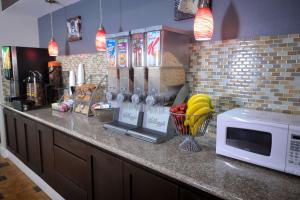 a kitchen counter with a microwave and a bowl of fruit at SureStay Hotel by Best Western Terrell in Terrell