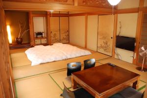 a room with a bed and a table and chairs at 一棟貸し平戸よこた in Hirado