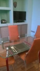 リペツクにあるЛофт-апартаменты с каминомのガラステーブル(オレンジ色の椅子付)、薄型テレビが備わります。
