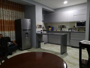 钦博特Hotel Real Chimbote的配有冰箱和桌子的厨房