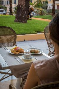 a woman sitting at a table with a plate of food at Mediterraneo Emotional Hotel & Spa in Santa Margherita Ligure
