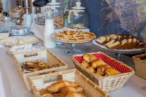 a table topped with baskets of pastries and pies at Mediterraneo Emotional Hotel & Spa in Santa Margherita Ligure
