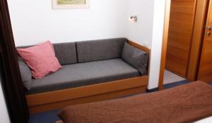 a couch with a red pillow on it in a room at Apart Hannah in Uderns +3 photos