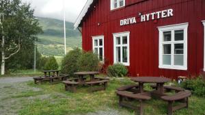 a group of picnic tables in front of a red building at Driva Hytter in Oppdal