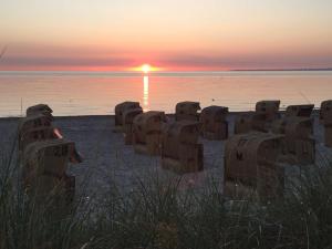 a group of concrete seats on the beach at sunset at Ferienwohnung Beachhus in Scharbeutz