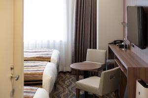 大阪市にあるホテルマイステイズプレミア堂島のベッドとテレビ付きのホテルルーム