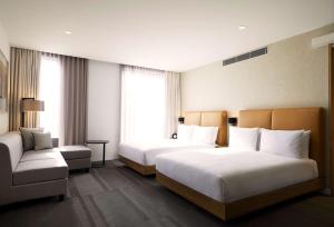 a hotel room with two beds and a couch at Hyatt Place Melbourne Essendon Fields in Melbourne