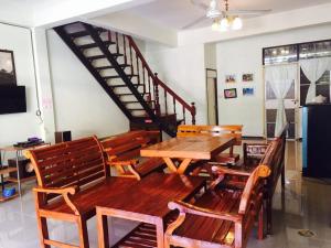 a dining room with a wooden table and chairs at Baan Khun Nong in Ban Hat Chao Samran