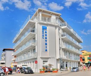 a white building with a blue sign on it at Hotel Austria in Caorle