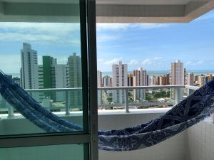 a window with a view of a city skyline at Essencial Manaíra in João Pessoa