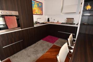a kitchen with brown cabinets and a red rug at The Jasmine Terrace Retreat in Bologna