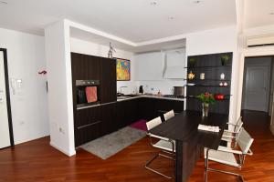 a kitchen and dining room with a black table and chairs at The Jasmine Terrace Retreat in Bologna