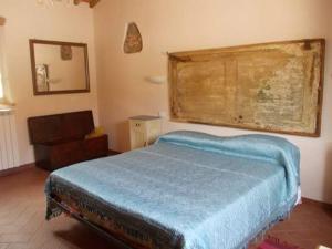 a bedroom with a blue bed and a chair at Agriturismo L'isola in Crespina