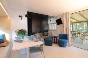 a living room with a white table and blue chairs at Green Resort in Ondres